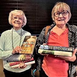 Lakewood residents Jeanette Hurlow and Leanna Jensen hold newly donated hardback books destined for museum’s shelves.